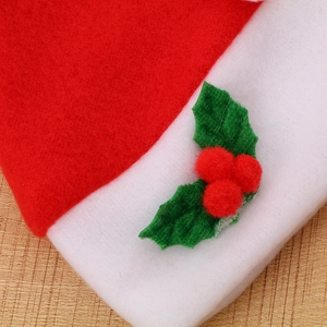Close-up of festive Christmas hat with red pompom and holly leaf felt decoration