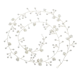 Close-up of handmade white flower and pearl beaded bridal hair accessory with metal wire