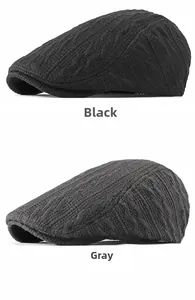 Detail view of knitted beret hats in black and grey featuring premium cable stitch texture