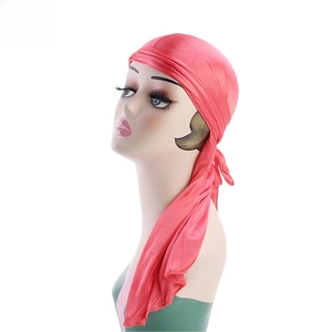 Detail of red silky satin durag with long straps on a mannequin head, shiny fabric texture