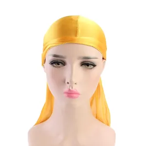 Silky yellow durag for waves with long tail straps shown on a female mannequin head