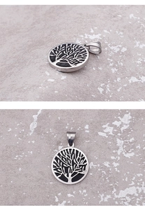 Macro views of a silver stainless steel round pendant with a black Tree of Life engraving