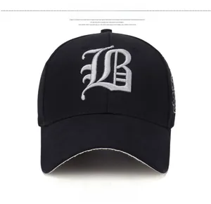 Detail of a black cotton baseball cap showing large white gothic letter B embroidery