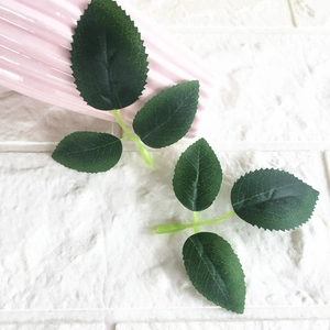 Detailed close-up of dark green faux rose leaves showing realistic veins and textures