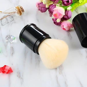 Close-up of retractable kabuki brush with soft bristles on white marble surface