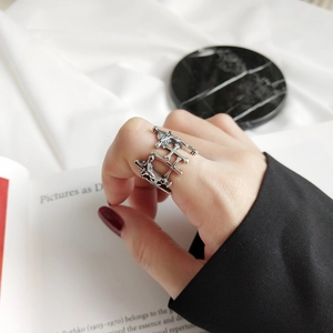 Detail view of a 925 sterling silver vintage cross ring on a hand with aesthetic marble background