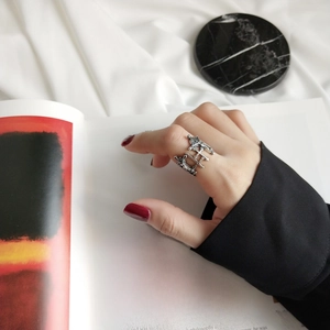 Detailed view of layered gothic cross sterling silver ring on model finger