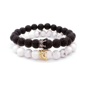 Vue macro de bracelets en pierre de lave et howlite avec des charmes de couronne en zircon