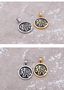 Detailed view of silver and gold elephant pendants with intricate cutout on marble surface