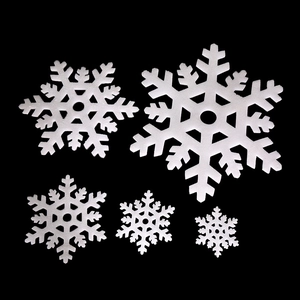 Detail of 5 different sized white foam snowflake decorations for holiday window display