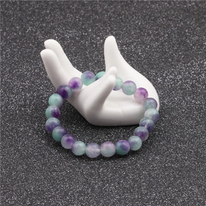 Macro view of 10mm purple and green natural stone beaded bracelet on white hand display