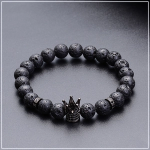 Macro detail of 8mm lava stone beads and micro-paved black crown charm on beaded bracelet