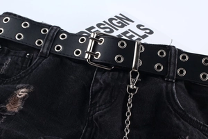 Detailaufnahme von Punk-Gürtel mit Doppelösen und Metallkette auf schwarzem Denim