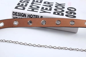 Detailansicht brauner Punk-Gürtel mit silbernen Metallösen und dekorativer Gliederkette