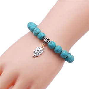 Detailed shot of 10mm turquoise beaded bracelet with silver owl charm on wrist