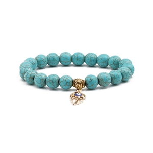 Macro view of 10mm turquoise beads bracelet with a gold evil eye leaf charm detail