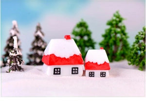 Detailed view of red snow-covered Christmas cottage miniatures for festive winter decor
