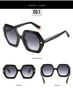 Close-up of hexagonal sunglasses with gold rivets and black thick frames on white background