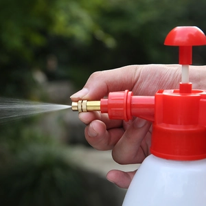 White and red plastic garden pressure sprayer with adjustable brass nozzle for watering plants