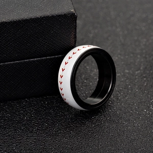 Close-up of white baseball spinner ring with red stitching on a black jewelry box