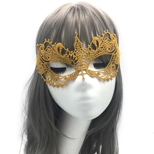 Detailed close-up of a gold lace phoenix mask featuring an intricate hollow-out design