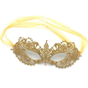 Detail of golden lace phoenix mask with yellow silk ribbon for masquerade party