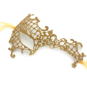 Detailed view of golden lace masquerade mask with intricate embroidery and satin ribbons