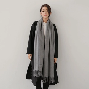 Elegant long gray cashmere scarf with tassel edges paired with a stylish black winter coat
