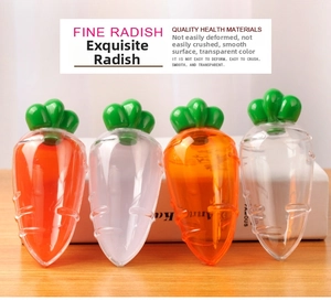 Close-up of carrot shaped plastic candy boxes in orange and clear colors on wood