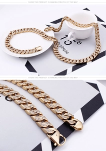 Detail of a luxurious gold Cuban link chain with dense rhinestone pavé and lobster clasp