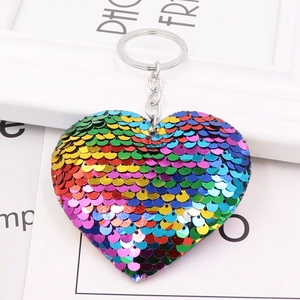Rainbow sequin heart keychain with metal ring shown on a decorative gift card background
