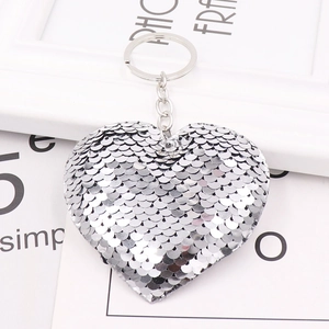 Macro shot of silver heart-shaped sequin keychain with reflective metallic texture
