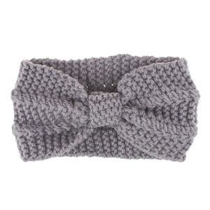 Close-up of winter knit headband showing thick textured grey yarn and bow detail