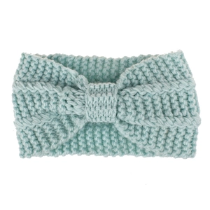 Detail of mint green knitted winter headband featuring a thick chunky bow design
