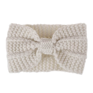 Macro shot of chunky white knitted winter headband featuring a stylish bow knot detail
