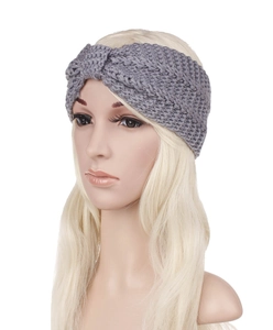 Close-up of a grey chunky cable knit headband with a stylish twisted knot detail