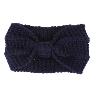 Macro detail of dark blue knitted headband showing thick yarn texture and knot design