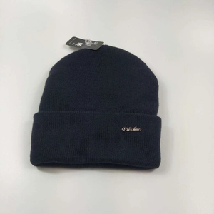 Detail of dark blue knit beanie with a metallic Pifulmo logo and soft ribbed texture