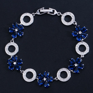 Detaillierte Makroansicht von Silber-Blumenarmband mit blauen Zirkonia auf schwarzem Grund