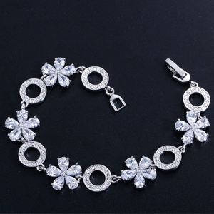 Details des silbernen Blumenarmbands mit Zirkonia-Steinen auf schwarzem Hintergrund