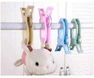 Strong plastic quilt clips with metal rings holding a plush toy on a white drying rod