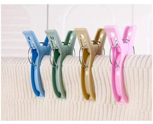 Macro detail of large colorful windproof quilt clips clamping thick white fabric