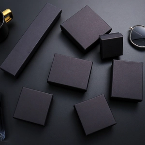 Various matte black jewelry gift boxes for rings and necklaces on dark background