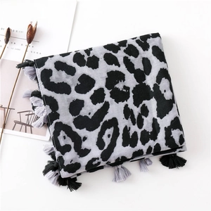 Close-up of leopard print scarf featuring bicolor tassels and soft woven fabric texture