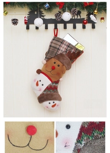 Detail of Christmas stocking with reindeer design, knitted textures and plush trim on wood