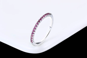 Close-up of elegant rose gold ring featuring a row of micro-pave set red zircons