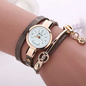 Detail of a rose gold wrap watch with multi-strand strap and a rhinestone angel bracelet