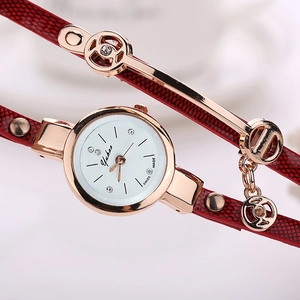 Detailed close-up of white quartz watch dial with rose gold case and red embossed strap