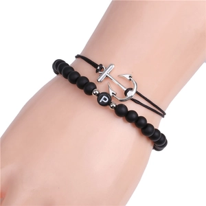 Close-up of 6mm matte black stone beaded bracelet with letter P and silver anchor charm