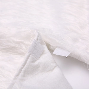 Close-up of the plush white faux fur Christmas tree skirt showing Velcro strap detail